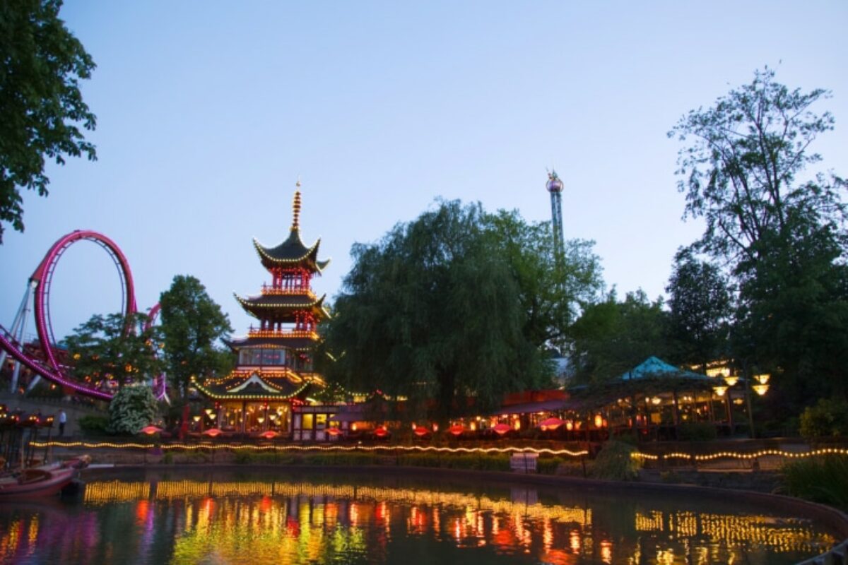 Verlichte pagode en vijver in Tivoli tijdens een sfeervolle avond.
