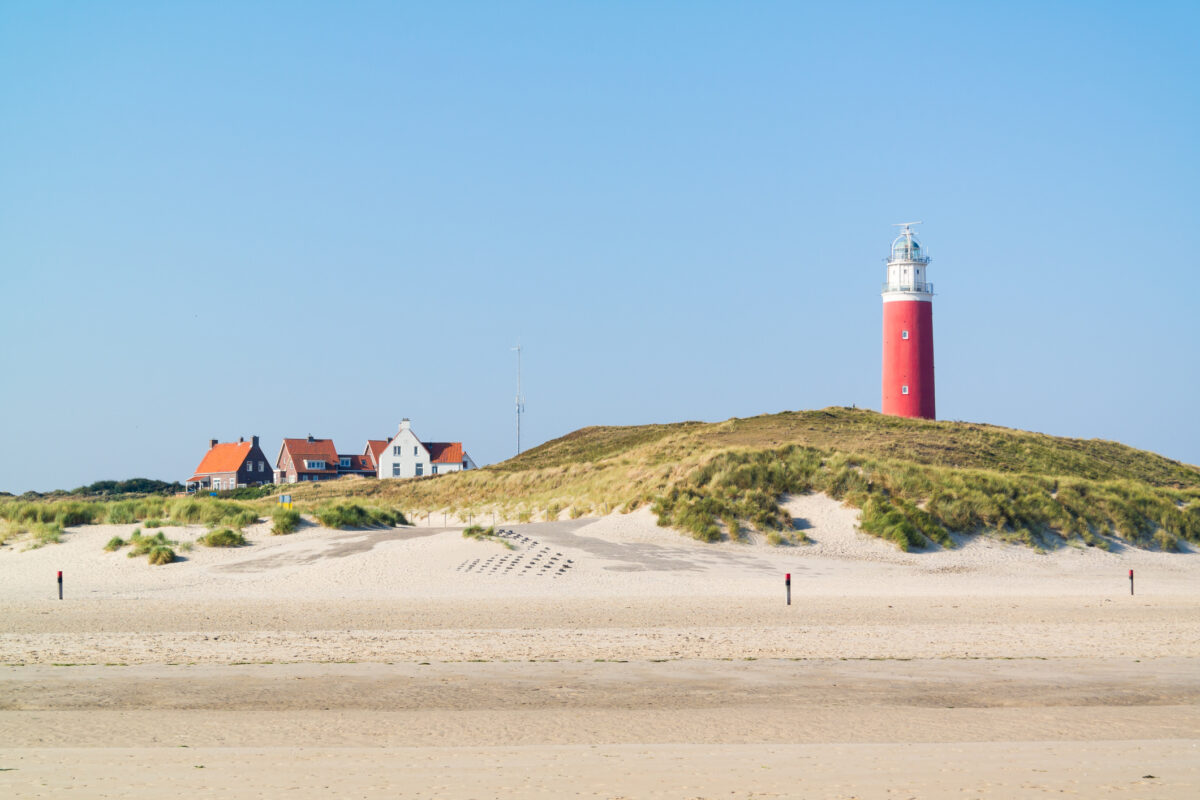 Zomerlandschap op Texel met duinen, strand en blauwe lucht.