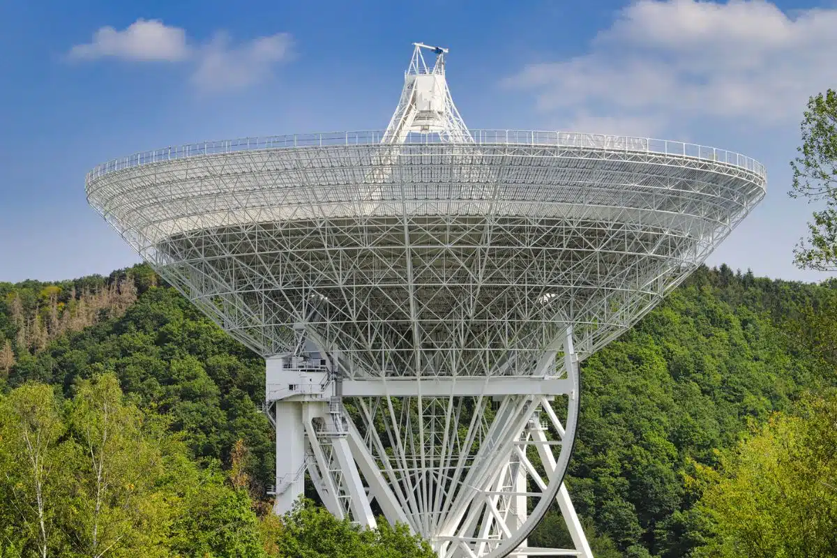 De radiotelescoop van Effelsberg in de Eifel, Duitsland – een enorme witte schotelantenne midden in het groene heuvelachtige landschap.