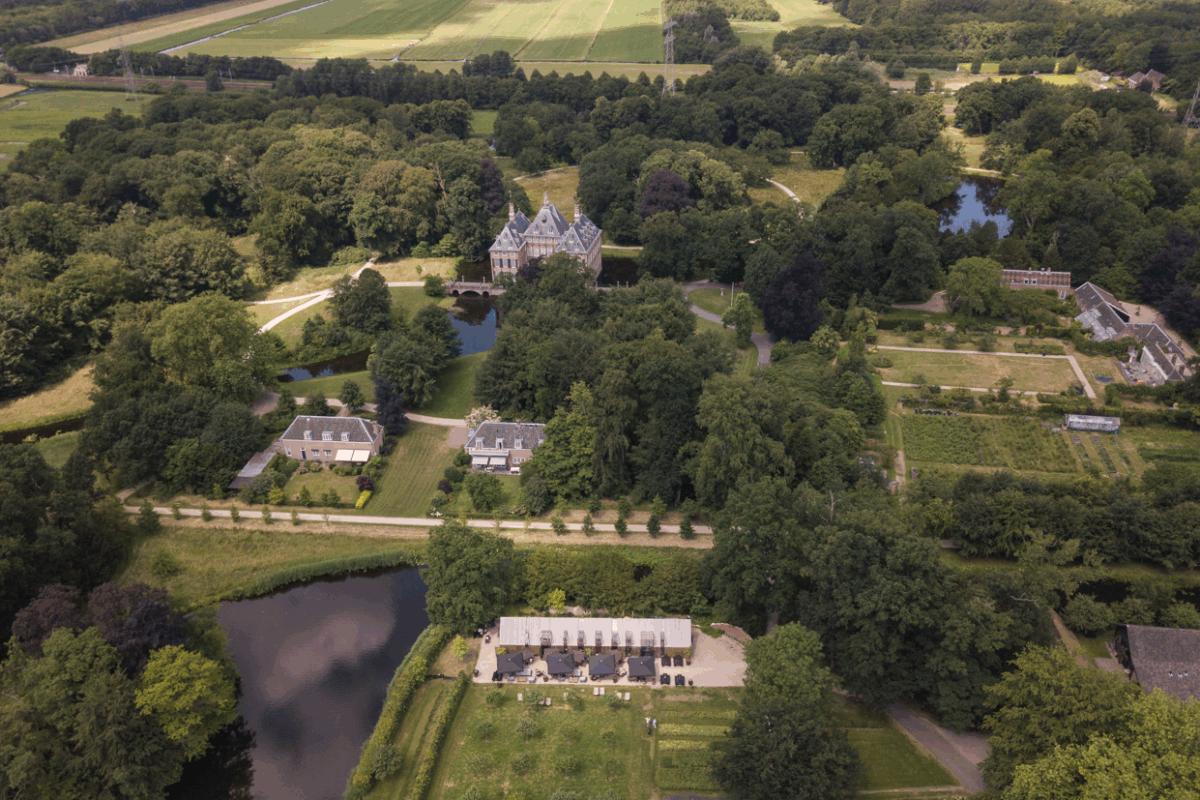 Luchtfoto van Kasteel Duivenvoorde in Voorschoten, omringd door bos, tuinen en waterpartijen.