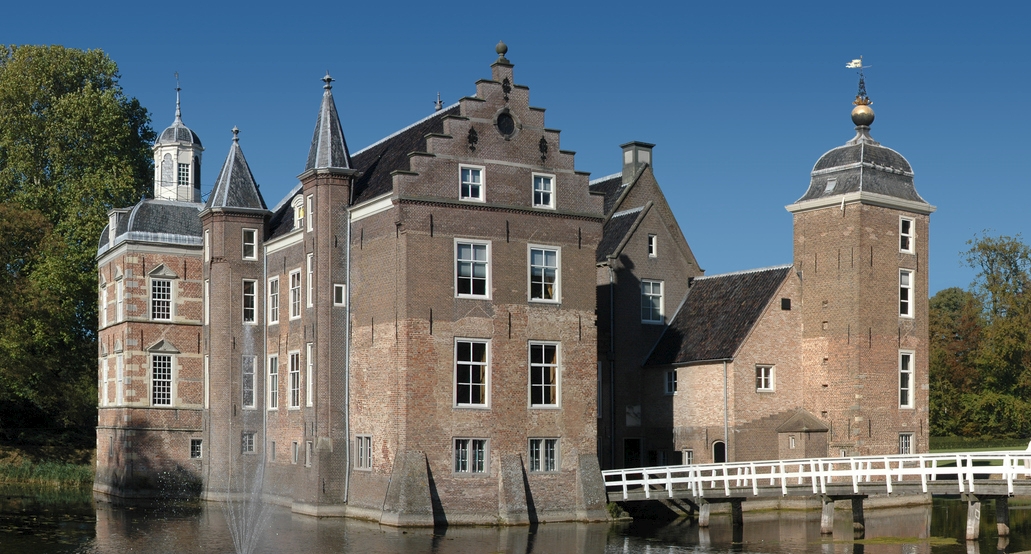 Voorzijde van Kasteel Ruurlo met zijn historische torens, gracht en witte brug op een zonnige dag een van de mooiste kastelen in Nederland