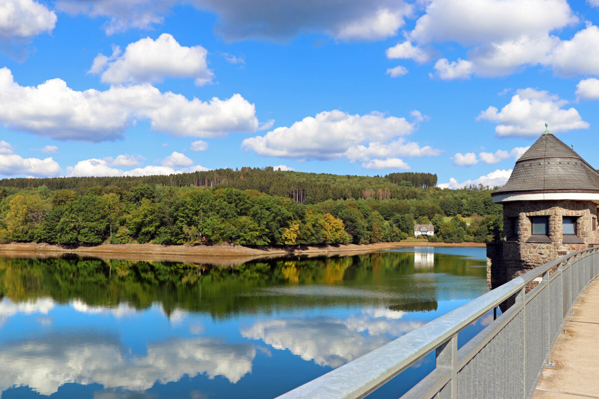 Listertalsperre aan de Biggesee met stuwdam, spiegelend water en beboste heuvels